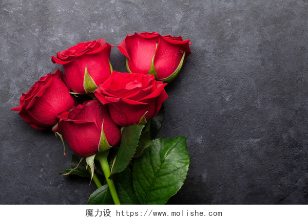 在黑色的桌子上有五朵鲜艳的玫瑰花情人节贺卡与红玫瑰花花束在石头的背景。为您的问候语提供空间的顶视图